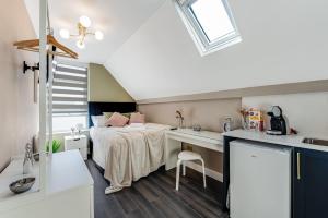 een slaapkamer met een bed en een bureau in een kamer bij Elegant Studio - Perfect for Explorers in Londen