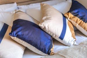 a bed with blue and white pillows on it at Elegant Studio - Perfect for Explorers in London