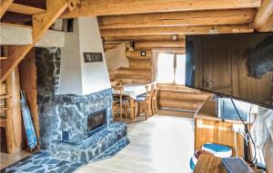 a living room with a stone fireplace in a log cabin at Amazing Home In Kopalino With 2 Bedrooms And Wifi in Kopalino
