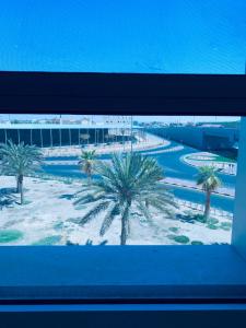 a view of a resort with palm trees from a window at شقق الروشن الجوفي in Al Fayşalīyah