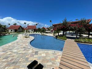 una piscina con passerella in legno accanto al resort di OKA Beach Residence a Porto De Galinhas