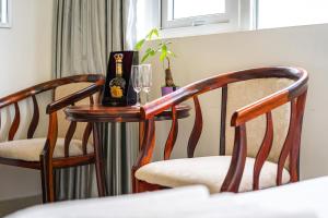 een tafel met twee stoelen en een glas wijn bij Miền Nhiệt Đới 2 Hotel in Da Lat