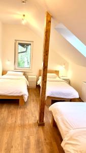 een slaapkamer op zolder met 2 bedden en een raam bij Petlov salaš rooms in Novi Sad