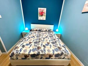a bedroom with a bed with a blue wall at Casa del Pescatore in Isola delle Femmine