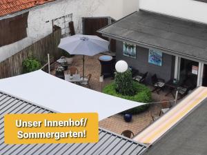 einen Blick über eine Außenterrasse mit Sonnenschirm in der Unterkunft Hotel Schlömer in Cloppenburg