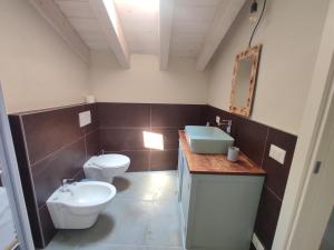 uma casa de banho com um WC branco e um lavatório. em La casa di Paolina - Affitti turistici CIR017067-LNI-00070 em Desenzano del Garda