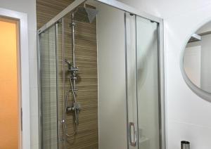 a shower with a glass door in a bathroom at Apartment Vils Promenade in Sarajevo