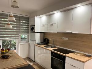 a kitchen with white cabinets and a sink at Apartment Vils Promenade in Sarajevo