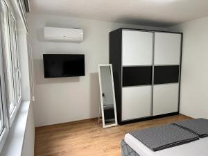 een slaapkamer met een spiegelkast en een tv bij Apartment Vils Promenade in Sarajevo