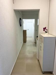 a hallway leading to a kitchen with a white refrigerator at Apartment Vils Promenade in Sarajevo