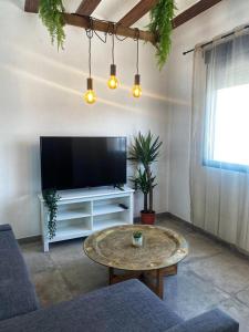 a living room with a tv and a coffee table at Agradable adosado con zona de aparcamiento in Sedaví