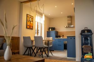 a kitchen with blue cabinets and a table and chairs at Gîte Ô Gré des Vosges 5 Étoiles Oberbronn, Vosges du Nord in Oberbronn
