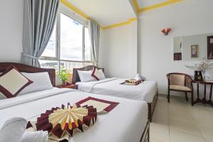 ein Hotelzimmer mit 2 Betten und einem Fenster in der Unterkunft Miền Nhiệt Đới 2 Hotel in Da Lat