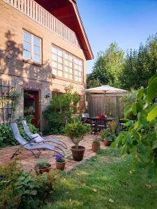 einen Garten mit einer Bank, einem Tisch und einem Sonnenschirm in der Unterkunft Ferienwohnung Hyggebo in Langballig