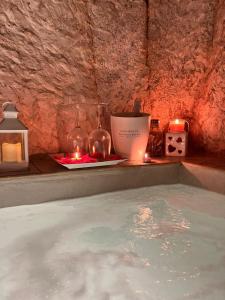 una vasca idromassaggio con candele e candele in una stanza di Tama67 suite a Ostuni