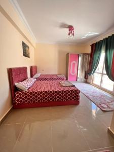 a bedroom with a red bed in a room at Coral hills North Coast كورال هيلز الساحل الشمالي in El Dab‘a