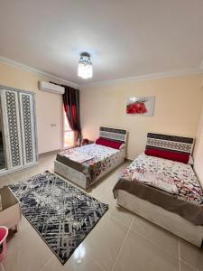 a bedroom with two beds and two rugs at Coral hills North Coast كورال هيلز الساحل الشمالي in El Dab‘a