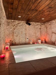 uma banheira num quarto com uma parede de pedra em Tama67 suite em Ostuni