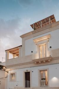 - un bâtiment blanc avec un balcon au-dessus dans l'établissement LE MAIOLICHE - Apulian B&B, à Grottaglie