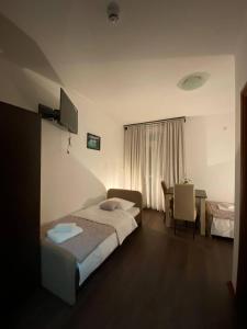 ein Hotelzimmer mit einem Bett und einem Tisch in der Unterkunft Podrinjski san in Loznica