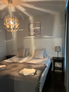 a bedroom with two beds and a chandelier at Galaxy Apartments Airport in Vantaa