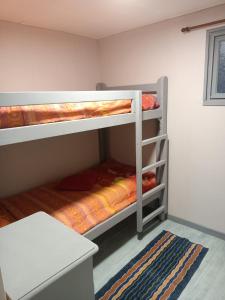Tempat tidur susun dalam kamar di Entre Puy-de-Dôme et Corrèze Appartement pour 4 personnes avec terrasse et jardin
