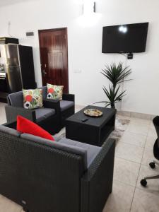 a living room with two couches and a tv at Emma's Guest House and Self-Catering in Au Cap