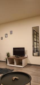 uma sala de estar com uma televisão de ecrã plano sobre uma mesa em CBT Apartament em Timisoara