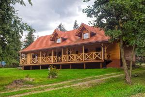 a large wooden house with a large deck at Kowalówka - Noclegi w Beskidzie Niskim in Męcina Wielka