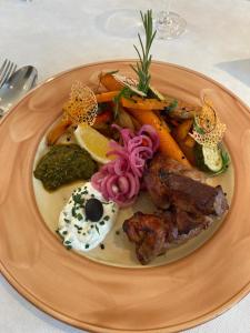 a plate of food with meat and vegetables on a table at Kolossos Apartments zum Sporthafen Neuss in Neuss