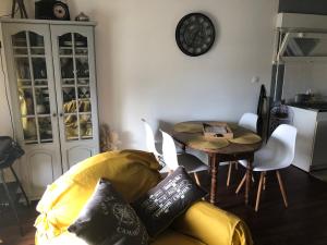 ein Wohnzimmer mit einem gelben Sofa und einem Tisch in der Unterkunft LISACA in Camaret-sur-Mer