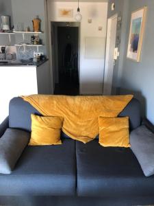 a couch with a yellow blanket on top of it at LISACA in Camaret-sur-Mer