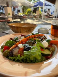 a plate of salad with vegetables on a table at Kolossos Apartments zum Sporthafen Neuss in Neuss