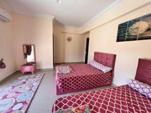 a room with two beds and a couch and a mirror at Coral hills North Coast كورال هيلز الساحل الشمالي in El Dab‘a