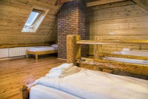 a room with three beds in a wooden cabin at Kowalówka - Noclegi w Beskidzie Niskim in Męcina Wielka