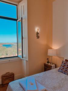 a bedroom with a bed and a large window at Chalet Santa Iria in Santarém