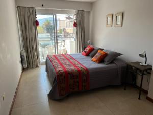 a bedroom with a bed with orange pillows on it at Carol 1 in Salta