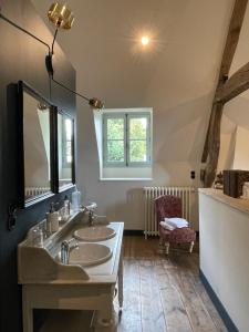 uma casa de banho com 2 lavatórios e um espelho em Château de Contay Guesthouse - 1753 em Contay