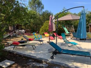 a group of chairs and umbrellas on a playground at Maison d'Hôtes Domaine de Labelo in Commensacq