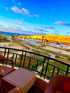a balcony with a view of a beach and the ocean at Coral hills North Coast كورال هيلز الساحل الشمالي in El Dab‘a