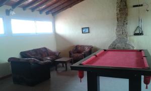 sala de estar con mesa de billar y 2 sillas en Petit Hotel en Las Toninas