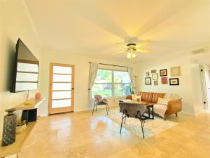 a living room with a ceiling fan and a table and chairs at CasaBreeze Cozy Creek House/IRB&Clearwater Beach! in Largo