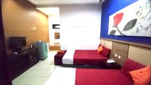 a hotel room with a bed and a large screen at Ahlen Pangandaran in Pangandaran