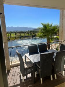 d'une table et de chaises sur un balcon avec vue sur l'eau. dans l'établissement Luxueux appartement Ritz Carlton Marina Smir, à Sania Torres