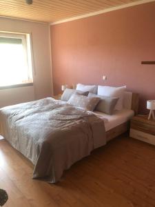 1 dormitorio con 1 cama grande con almohadas blancas en Ferienwohnung Klosterblick, en Bastheim