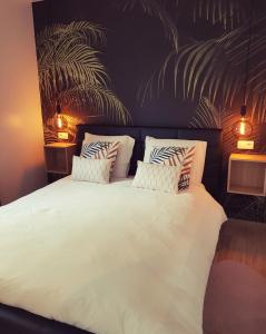 a bedroom with a large white bed with two pillows at L'Essentiel à Francorchamps in Francorchamps