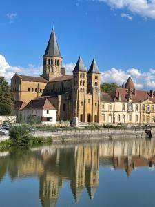 a large building with a reflection in a body of water at Les Logis de Paray Appartement 202 in Paray-le-Monial