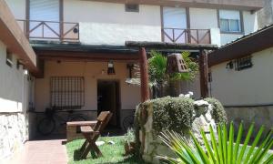 una casa con un banco delante de ella en Petit Hotel en Las Toninas