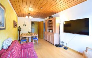 a living room with a television and a table with chairs at Nice Apartment In Racines-ratschings With Wifi in Stanghe