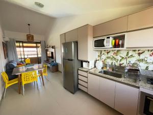una cucina con lavandino, tavolo e forno a microonde di OKA Beach Residence a Porto De Galinhas